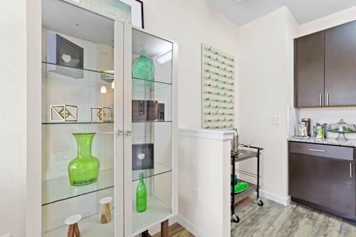 a glass display case with green vases in a kitchen