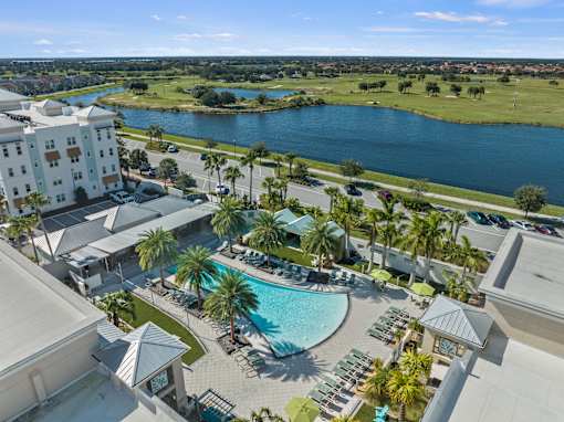A large swimming pool surrounded by palm trees and lounge chairs. at Centre Pointe Apartments, Florida