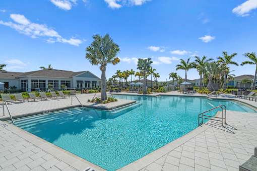 a large swimming pool with palm trees in front of a building at Artesia at Lakewood Ranch Apartments, Bradenton, 34211