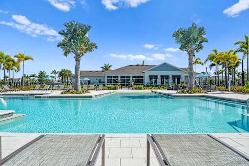 a large pool with palm trees and a building in the background at Artesia at Lakewood Ranch Apartments, Bradenton, FL
