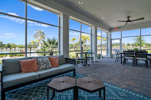 a living room with a couch and a table with chairs and windows at Artesia at Lakewood Ranch Apartments, Bradenton, 34211