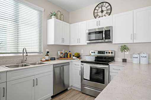 a kitchen with stainless steel appliances and white cabinetry at Soleil at Canyon Trails Apartments, Arizona