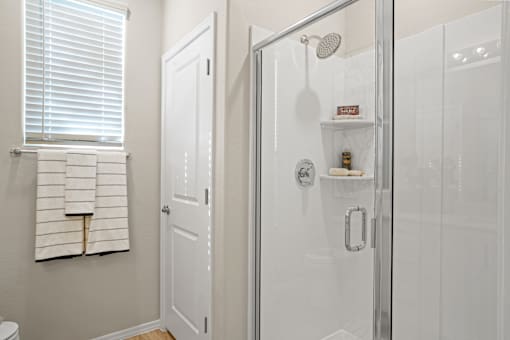 a white bathroom with a shower and a window at Soleil at Canyon Trails Apartments, Goodyear, Arizona