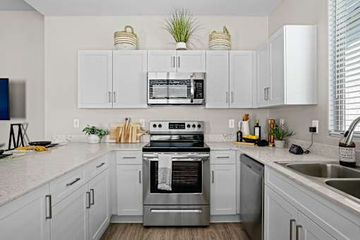 a large white kitchen with stainless steel appliances and white cabinets at Soleil at Canyon Trails Apartments, Arizona, 85338