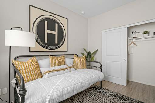 a white bedroom with a white bed and yellow pillows at Soleil at Canyon Trails Apartments, Goodyear