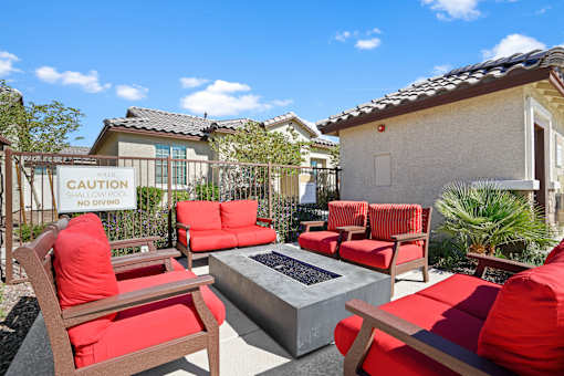a patio with red chairs and a fire pit at Soleil at Canyon Trails Apartments, Goodyear, 85338