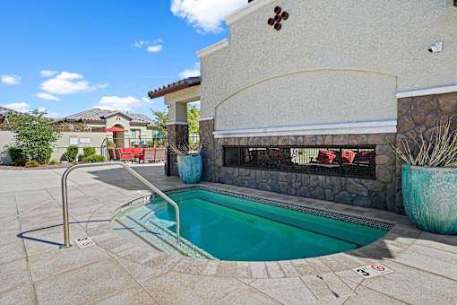 a swimming pool in front of a house with a pool at Soleil at Canyon Trails Apartments, Goodyear, Arizona