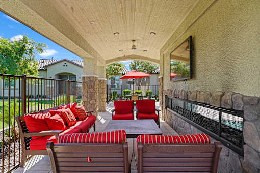 a covered patio with furniture and a table and chairs at Soleil at Canyon Trails Apartments, Goodyear, 85338