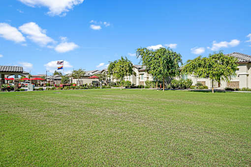 a large lawn with houses in the background at Soleil at Canyon Trails Apartments, Arizona