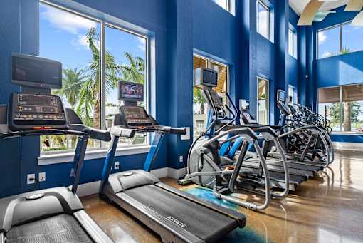 A row of treadmills in a gym with a view of the outside. at Centre Pointe Apartments, Melbourne, FL