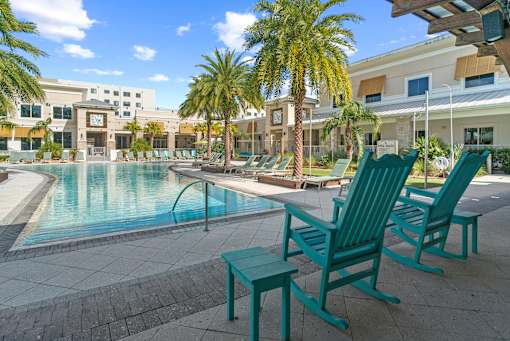 A pool area with a bench and chairs. at Centre Pointe Apartments, Melbourne