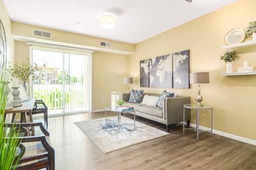 a living room with yellow walls and a sliding glass door at Skye at Arbor Lakes, Minnesota, 55369