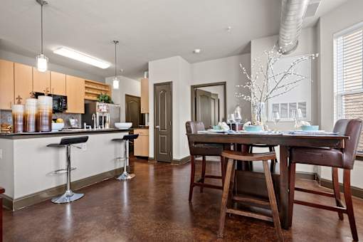 an open kitchen and dining room with a table and chairs at The Millennium Towne Center Apartments, Baton Rouge, LA