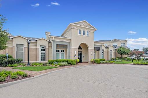 the front of a building with a driveway and walkway at The Millennium Towne Center Apartments, Baton Rouge