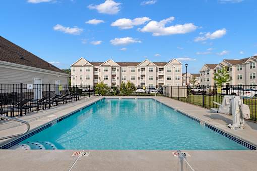 a swimming pool with apartment buildings in the background at The Landing Apartment, Hazlet, NJ, 07730