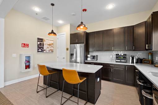 a kitchen with a large island with two orange chairs at The Landing Apartment , Hazlet