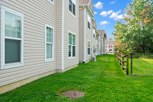a green lawn in front of a white house at The Landing Apartment , Hazlet, NJ