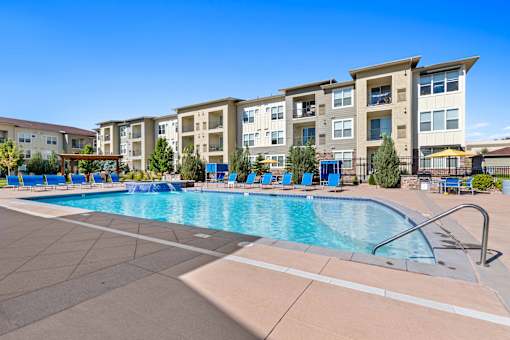 a swimming pool with an apartment building in the background