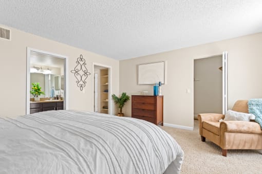a bedroom with a bed and a chair and a closet at Silver Reef Apartments, Lakewood, 80228