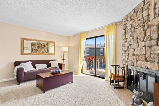 a living room with a stone fireplace and a couch at Silver Reef Apartments, Colorado, 80228