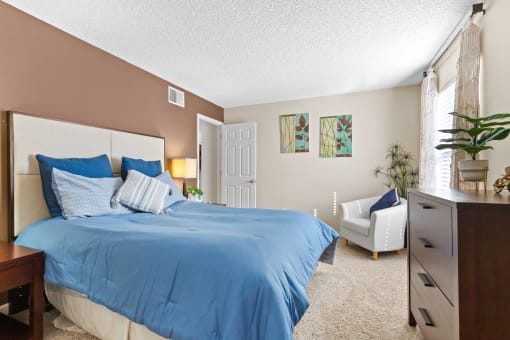 a bedroom with a bed and a chair and a dresser at Silver Reef Apartments, Colorado