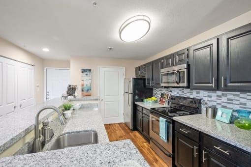 a kitchen with black appliances and granite counter tops at 150 Summit, Birmingham, Alabama