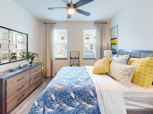 A bedroom with a bed, dresser, and ceiling fan. at Centre Pointe Apartments, Florida, 32940