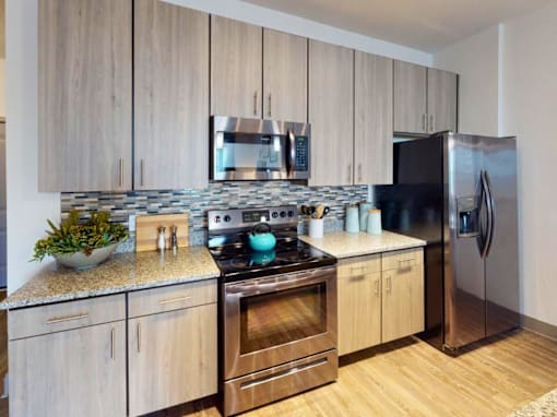 A modern kitchen with wooden cabinets and stainless steel appliances. at Centre Pointe Apartments, Melbourne, FL