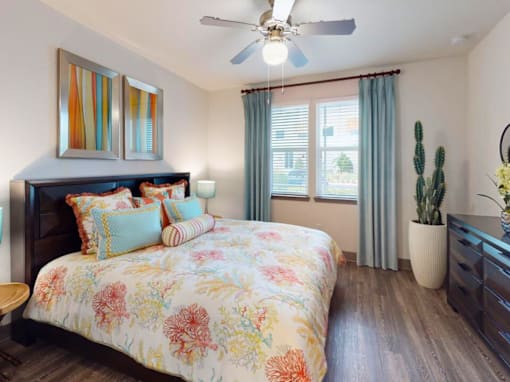 A bedroom with a floral bedspread and a ceiling fan. at Centre Pointe Apartments, Melbourne, 32940