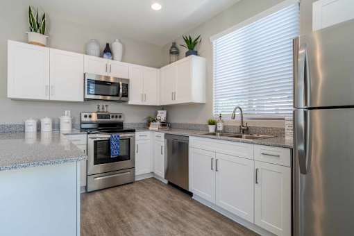 A kitchen with white cabinets and stainless steel appliances. at Vistoria At Marley Park Apartments, Arizona, 85379