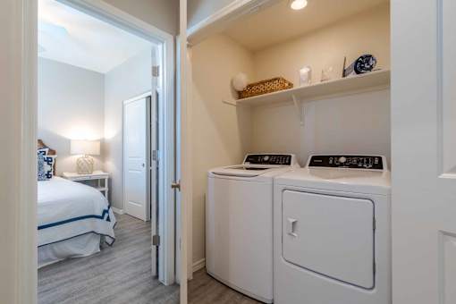 A small laundry room with a washer and dryer. at Vistoria At Marley Park Apartments, Surprise