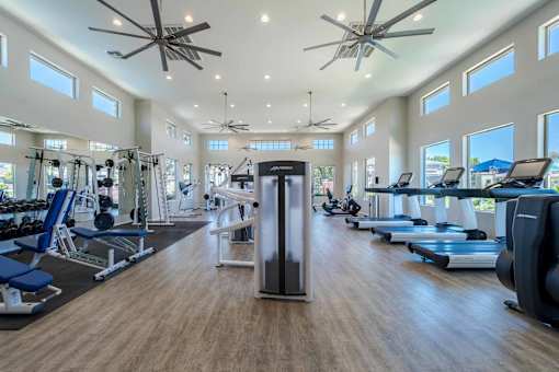 A spacious gym with a variety of equipment and a ceiling fan at Vistoria At Marley Park Apartments, Surprise, 85379