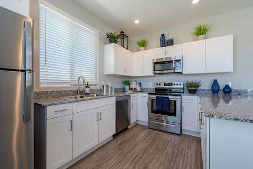 Modern kitchen with white cabinets and granite countertops at Vistoria On Mountain View Apartments, Arizona