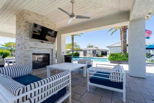 Covered patio with fireplace and pool at Vistoria On Mountain View Apartments, Surprise, 85374