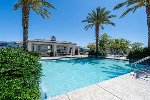 Resort style swimming pool with palm trees at Vistoria On Mountain View Apartments, Surprise, Arizona