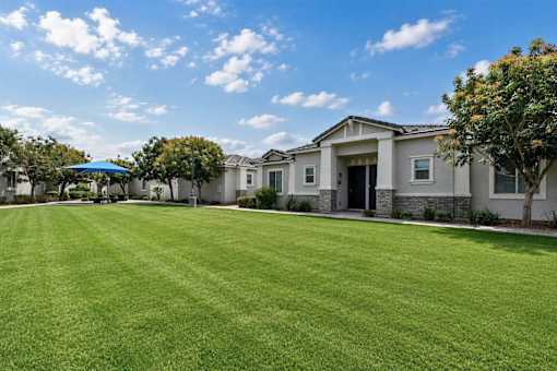 A row of houses with a green lawn in front.