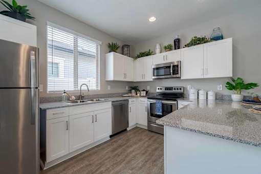 A kitchen with white cabinets and a granite countertop.