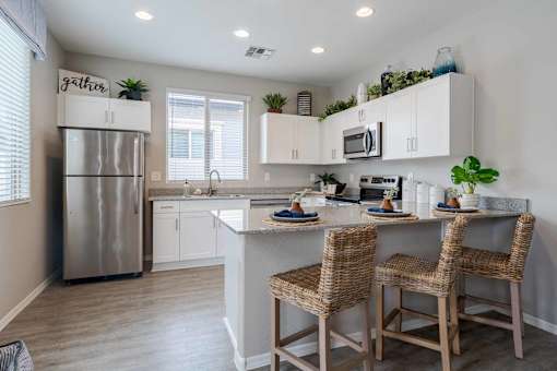 A kitchen with a refrigerator, sink, and countertop.