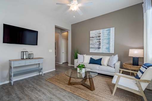 A living room with a white couch, a television, and a coffee table.