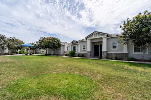 A house with a green lawn in front of it.