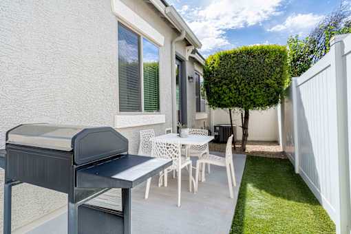 A white patio with a table and chairs. at Vistoria At Country Place Apartments, Tolleson, AZ, 85353