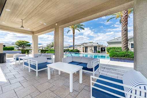 A patio with a pool and a striped cushion. at Vistoria At Country Place Apartments, Tolleson, Arizona
