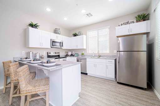 A modern kitchen with a center island and stainless steel appliances. at Vistoria At Country Place Apartments, Tolleson, 85353