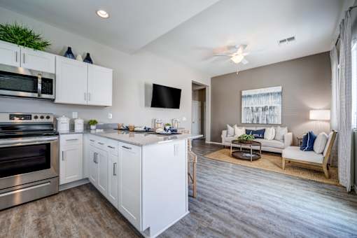 A modern kitchen with white cabinets and stainless steel appliances.