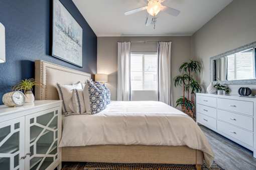A bedroom with a bed, dresser, and mirror.