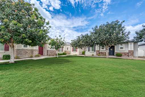A row of houses with green lawns in front.