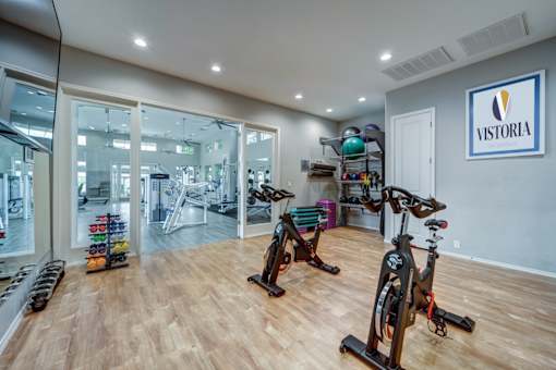 A gym with exercise equipment and a sign that says "Victoria".