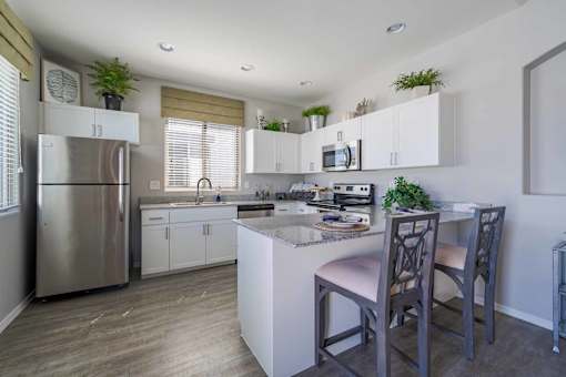 Modern kitchen with granite island seating at Vistoria On Greenway Apartments, Surprise, 85379