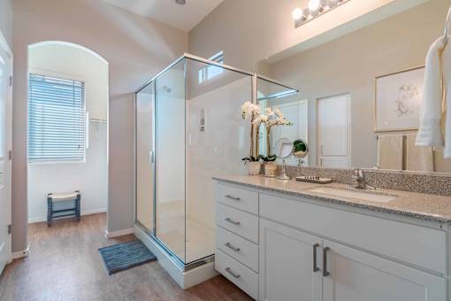 Master bathroom with glass shower enclosure at Vistoria On Greenway Apartments, Arizona