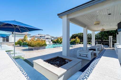 Covered outdoor patio with fire pit at Vistoria On Greenway Apartments, Surprise